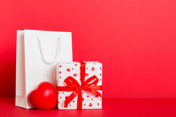 Shopping bag with gift box on colored background perspecrive view. Space for text holiday concept