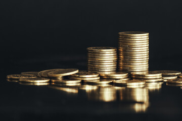 Close up of money coin stack on black background with selective focus. Business and financial background.
