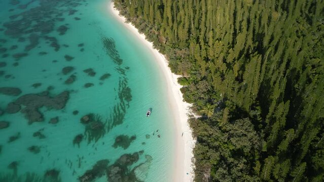 A small boat brings tourists to Brush Island, a deserted island off Kuto Bay, Isle of Pines - aerial orbit