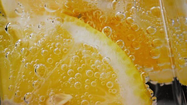 Bubbly Drink and Lemon Slices in Glass Cup Close Up. Making Sour Alcoholic Cocktail of Vodka or White Rum at Home on Studio Shot in Macro. Drinking Sparkling Water as Detox Fluid or Pure Mineral Aqua