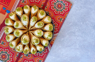 Arabian pancake Qatayef with qishta cream and pistachio . Traditional ramadan sweets . Top view, copy space