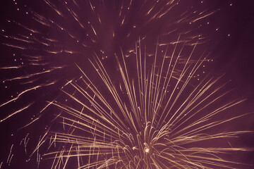ellow fireworks against violet night sky background