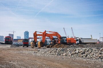 Excavators or diggers with dumper trucks on construction site or earthmoving at shore protection...