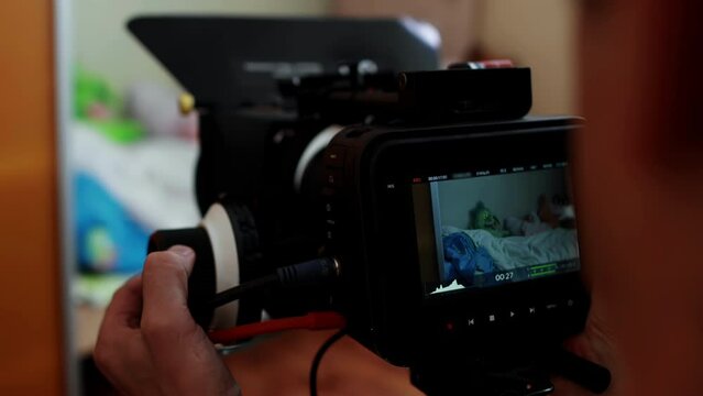 Cameraman operator with cinema camera shoots clapperboard dumb slate, clap sync. Backstage filming movie. Cinematography. Production of commercial ad TV series. Black device, magic design. Videography