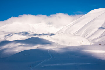 Beautiful sunlight and shades contrast on snow hills in winter