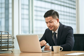 Fototapeta na wymiar asian business man working in office using laptop computer
