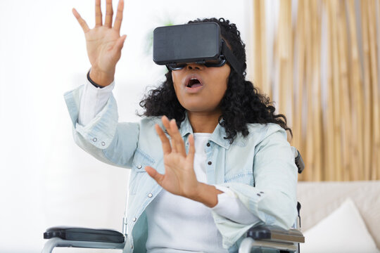 side view of woman on wheelchair using virtual reality mask