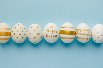 Easter background. Easter golden decorated eggs on blue background. Minimal easter concept. Flat Lay of Golden Easter Eggs