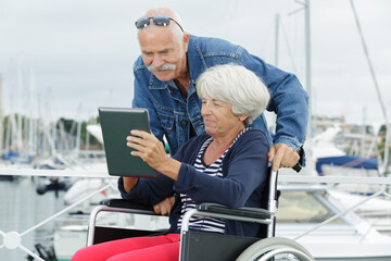 senior couple using tablet outdoors