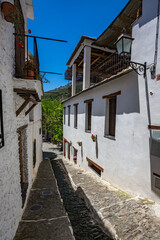 Very narrow street in the old village of Pampaneira, Andalusia, Spain, whitewashed houses