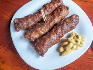 delicious grilled minced meat rolls mici ori mititei traditional romanian and balkan dish served with mustard