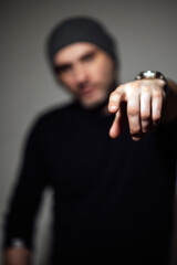 Serious dramatic man looking away while standing against black studio background