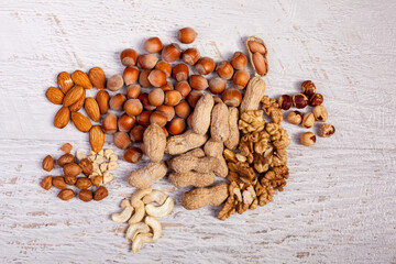 Different type of nuts of white wooden background. Healthy food