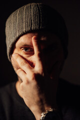 Serious dramatic man looking away while standing against black studio background