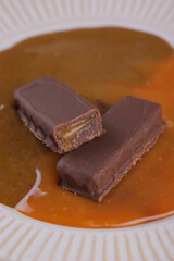 Sweet bar with caramel filling in caramel