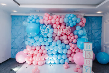 Photo zone, arch with pink and blue balloons, cubes for gender party. Boy or girl. Know gender of unborn child. Happiness of parenthood. Background, wall with text oh baby. Baby Shower party decor. - obrazy, fototapety, plakaty
