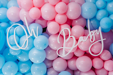 Photo zone, arch with pink and blue balloons for gender party. Boy or girl. Know gender of unborn child. Happiness of parenthood. Background, wall with text oh baby. Baby Shower party decor. Closeup. - obrazy, fototapety, plakaty