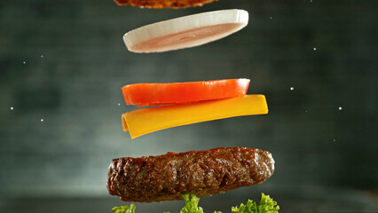 Cheeseburger with flying ingredients, realistic freeze motion.