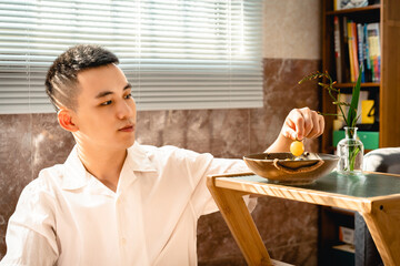 Asian young man is eating fruits at home.