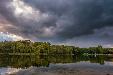 Natural landscape of the lake, high definition, the movement of waves against the background of the autumn forest. The reflection of clouds on the ripples of water. Germany.