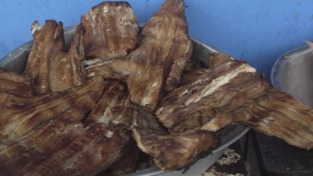 Close up and pan right of fried shark and red snapper at street fish market in Buenaventura. Colombian Pacific coast. 