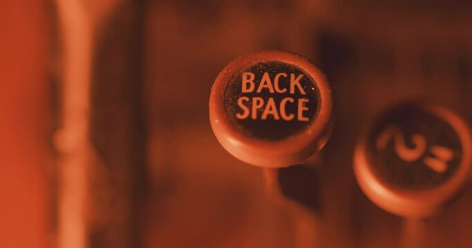 Finger pressing 'back space' key on an old vintage typewriter - close up