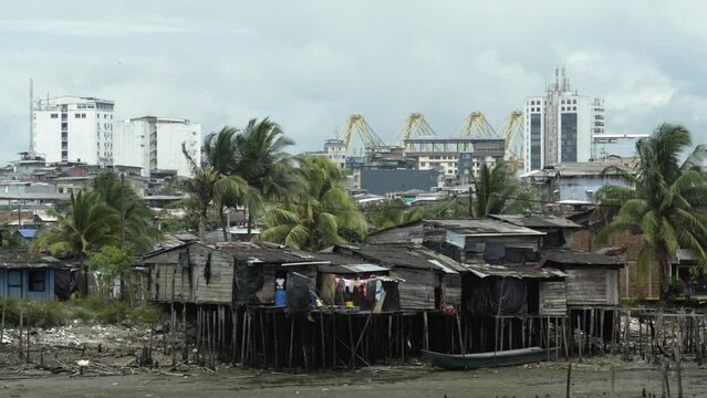 Wide shot of stilt houses in foreground and city buildings in the background of Buenaventura