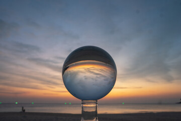 view of colorful nature at sunset inside crystal ball..beautiful sunset over sea in a crystal ball on the beach. .Nature High quality footage in nature and travel concept.