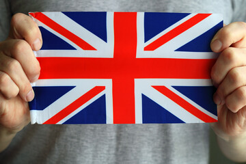 Close-up of the UK flag, in male hands. Flag of the Great Britain.
