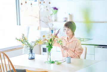 Fototapeta na wymiar 部屋で花を生ける女性