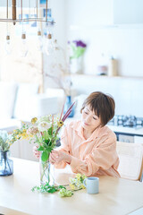 部屋で花を生ける女性