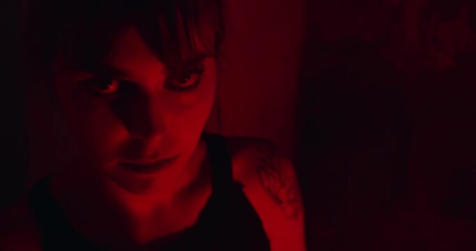 Psychopath Woman With Angry Glare On Her Face In Dark Red Lit Room. closeup