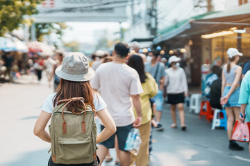 woman traveler visiting in Bangkok, Tourist with backpack and hat sightseeing in Chatuchak Weekend Market, landmark and popular attractions in Bangkok, Thailand. Travel in Southeast Asia concept