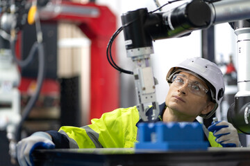 Industrial engineer working on robot arm maintenance in modern technology factory. Technician...