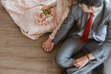 asian brides holding hands while sitting together on the floor