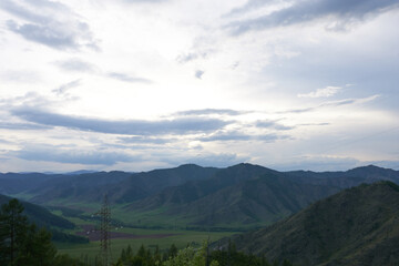 Panoramic view of the mountains in the evening in variable weather. The Altai Mountains.
