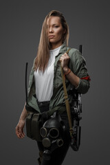 Fototapeta na wymiar Portrait of killer woman with rifle in post apocalyptic style against gray background.