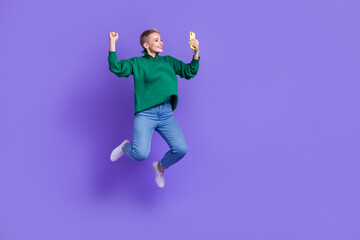 Full length photo of shiny lucky lady wear green sweater winning game modern gadget empty space isolated violet color background