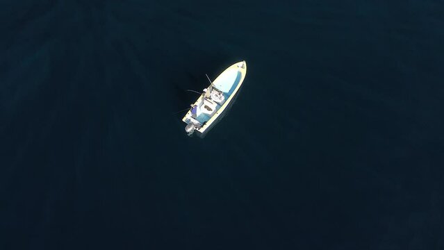 Aerial perspective of angler hurriedly reeling in fish caught on bent rod