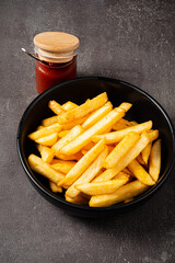 french fries with sauce on the dark background