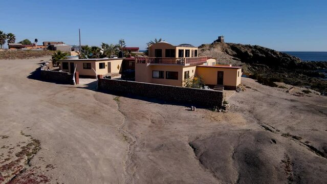 Aerial orbit around tropical villa ontop of seacliffs by the beach