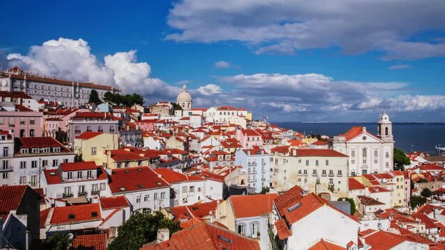 Time-lapse of Lisbon famous view from Miradouro de Santa Luzia tourist viewpoint over Alfama old city district, cruise liner and moving clouds. Lisbon, Portugal. Zoom out effect
