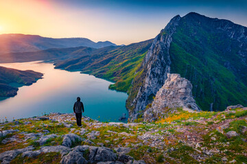 Tourist meets the sunrise on the edge of a cliff on Bovilla Lake, near Tirana city located....