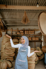 happy excited young muslim woman standing in front of her workshop