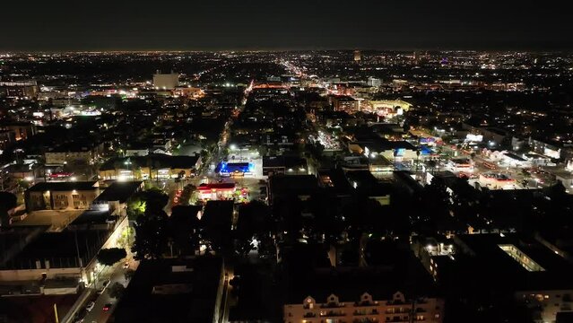 Aerial view flying across Hollywood Los Angeles night cityscape illuminated skyline