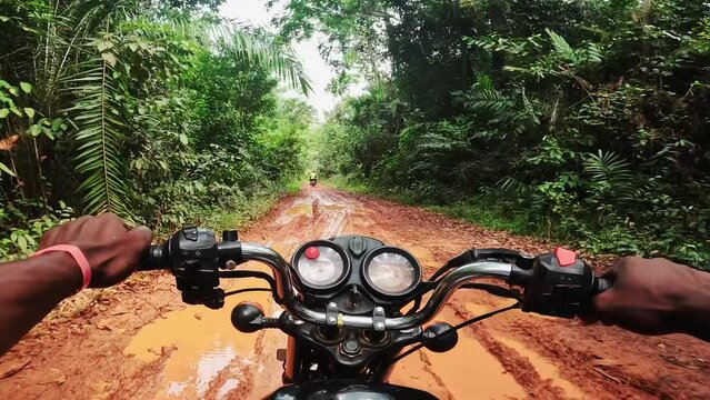 POV of a motorcyclist driving through the jungle of west africa near the border of Ivory Coast and Libeira