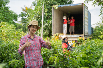Smart young farmer woman wearing hat with thumbs up on plantation, smart farmer concept