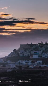 Beautiful evening sky at sunset over small city in Morocco ocean coast Time Lapse Vertical video