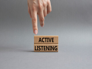 Active listening symbol. Wooden blocks with words Active listening. Businessman hand. Beautiful grey background. Business and Active listening concept. Copy space.