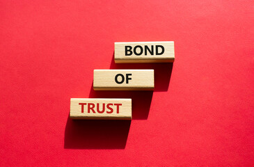 Bond of trust symbol. Wooden blocks with words Bond of trust. Beautiful red background. Business and Bond of trust concept. Copy space.